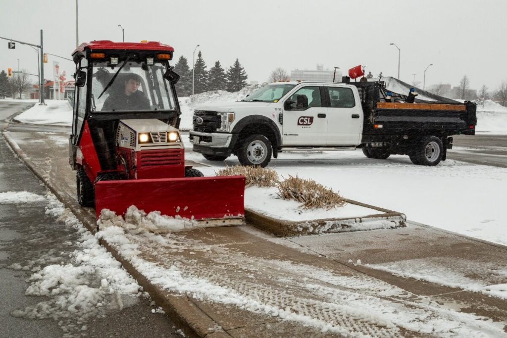 clearing snow from a sidewalk | How To Prepare Your Commercial Property For Winter